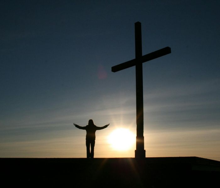 Silhouette of a person meditating during sunrise, symbolizing inner peace.