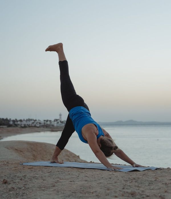 Woman in a peaceful yoga pose against a dark, calming background.